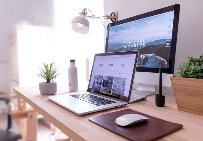 Ein aufgeräumter Schreibtisch mit aufgeklapptem Laptop